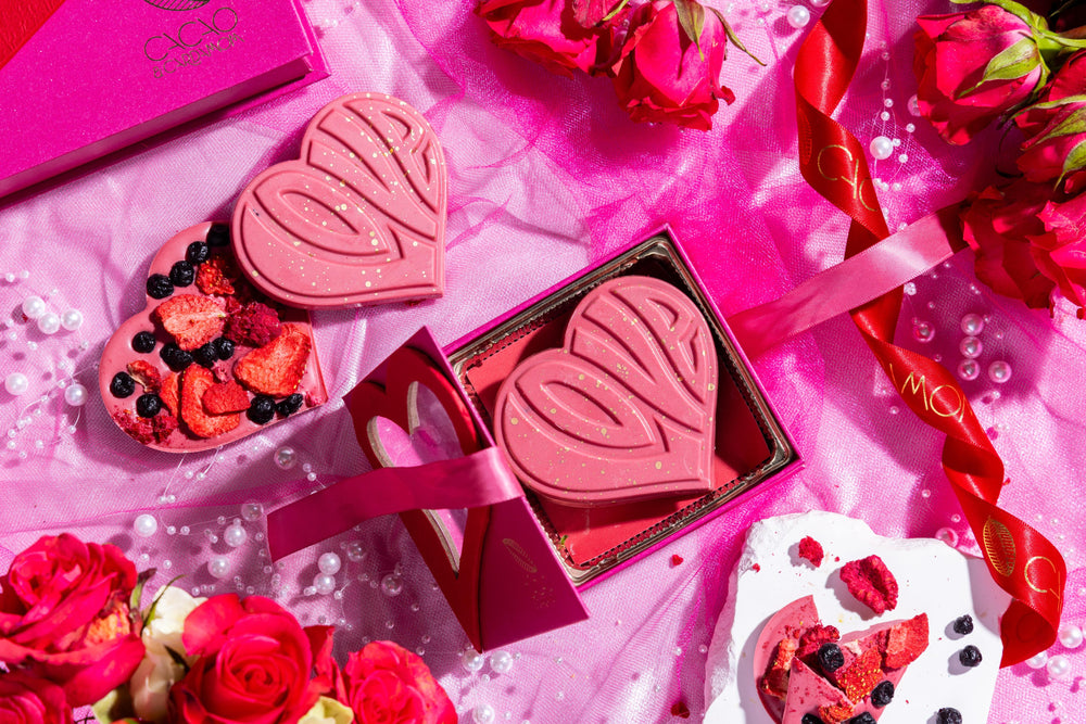 A heart-shaped pink chocolate bar with 'Love' written on it