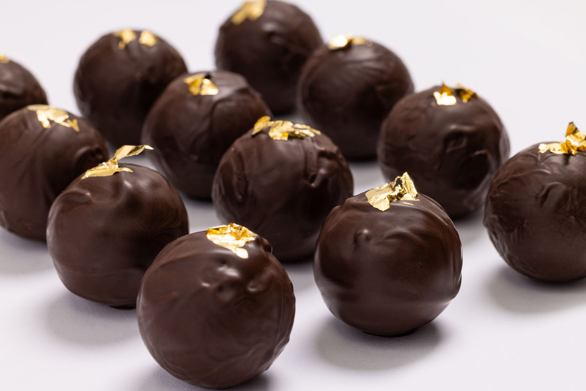 Open New Year's Champagne Truffles 12-piece gift box displaying handcrafted artisan chocolates.