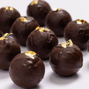 Open New Year's Champagne Truffles 12-piece gift box displaying handcrafted artisan chocolates.