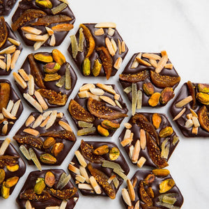 Open 72% Venezuelan Mendiants displaying handcrafted dark chocolate discs.